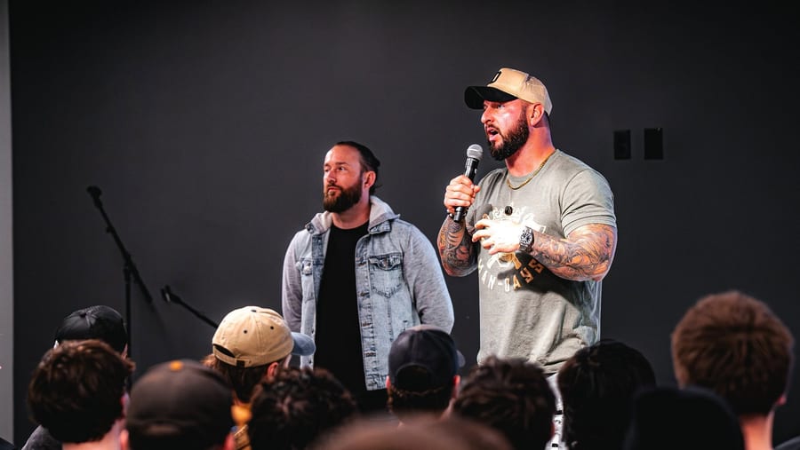 Caleb Scott speaking to the room with a microphone